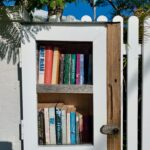 Little Library full of books in a fence