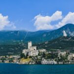 Town and castle of Malcesine against mountains blue sky and a lake