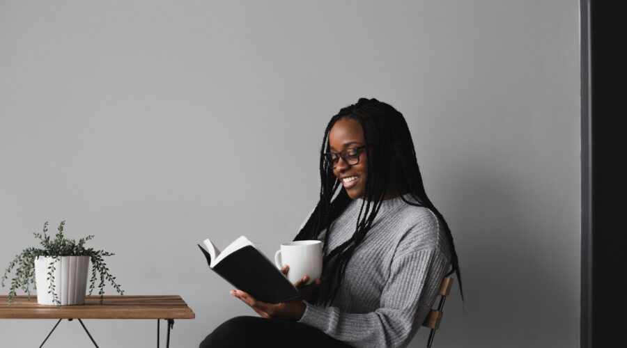 Reading list for Mother's Day - Roonee. A woman reading a book with a cup of tea in her hand