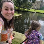 Alex with her daughter outside by a big pond