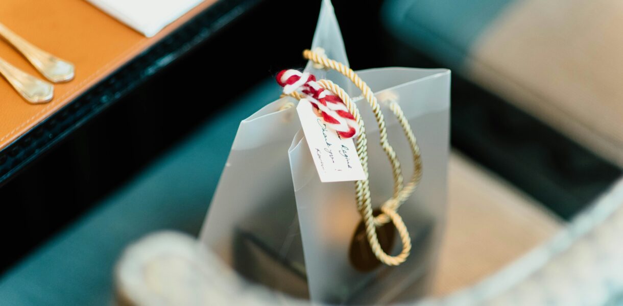 a silver gift bag with a hand written label