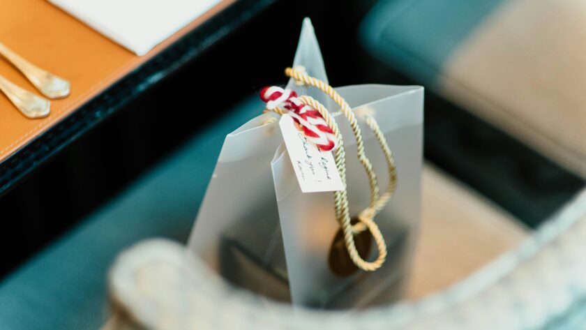a silver gift bag with a hand written label