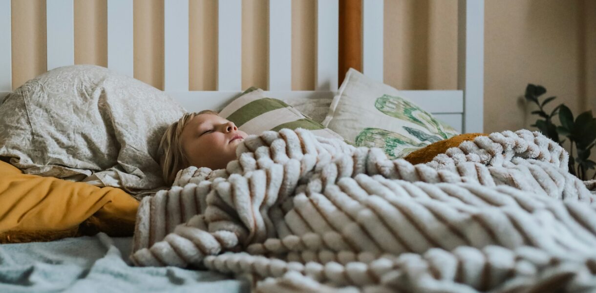 a child sleeps under a soft looking blanket