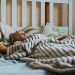 a child sleeps under a soft looking blanket