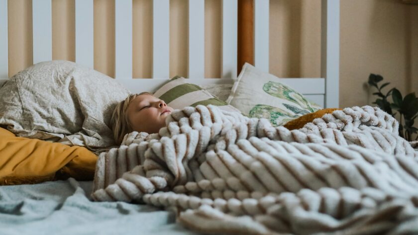 a child sleeps under a soft looking blanket