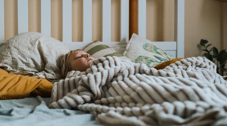 a child sleeps under a soft looking blanket