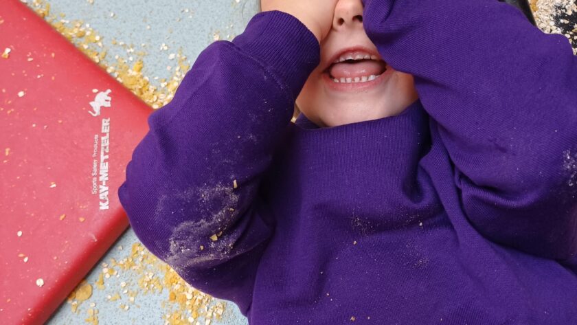 a happy child in a purple jumper