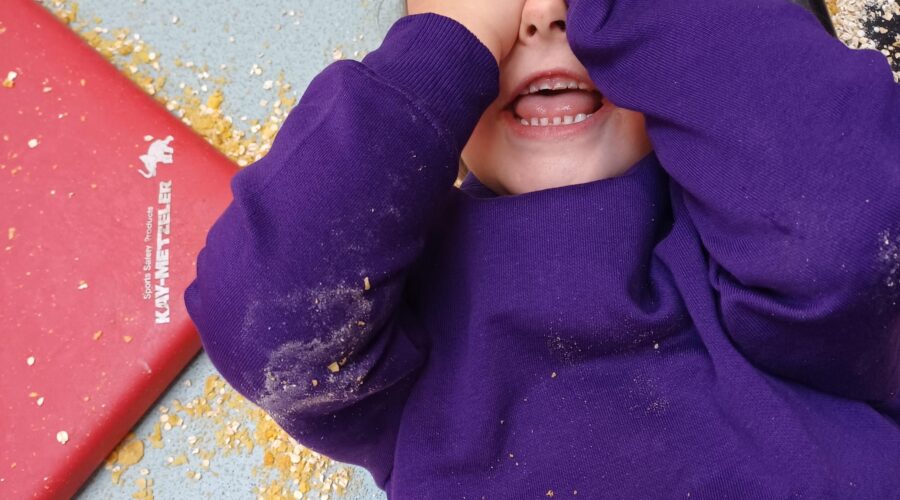 a happy child in a purple jumper